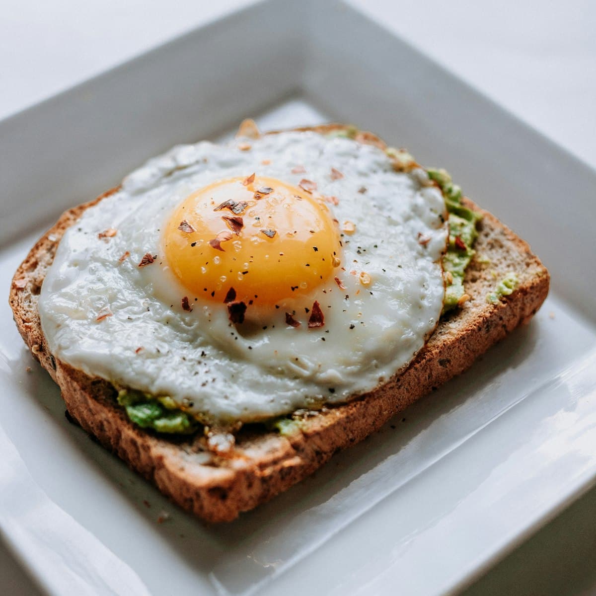Smashed avocado and a fried egg on toasted sourdough